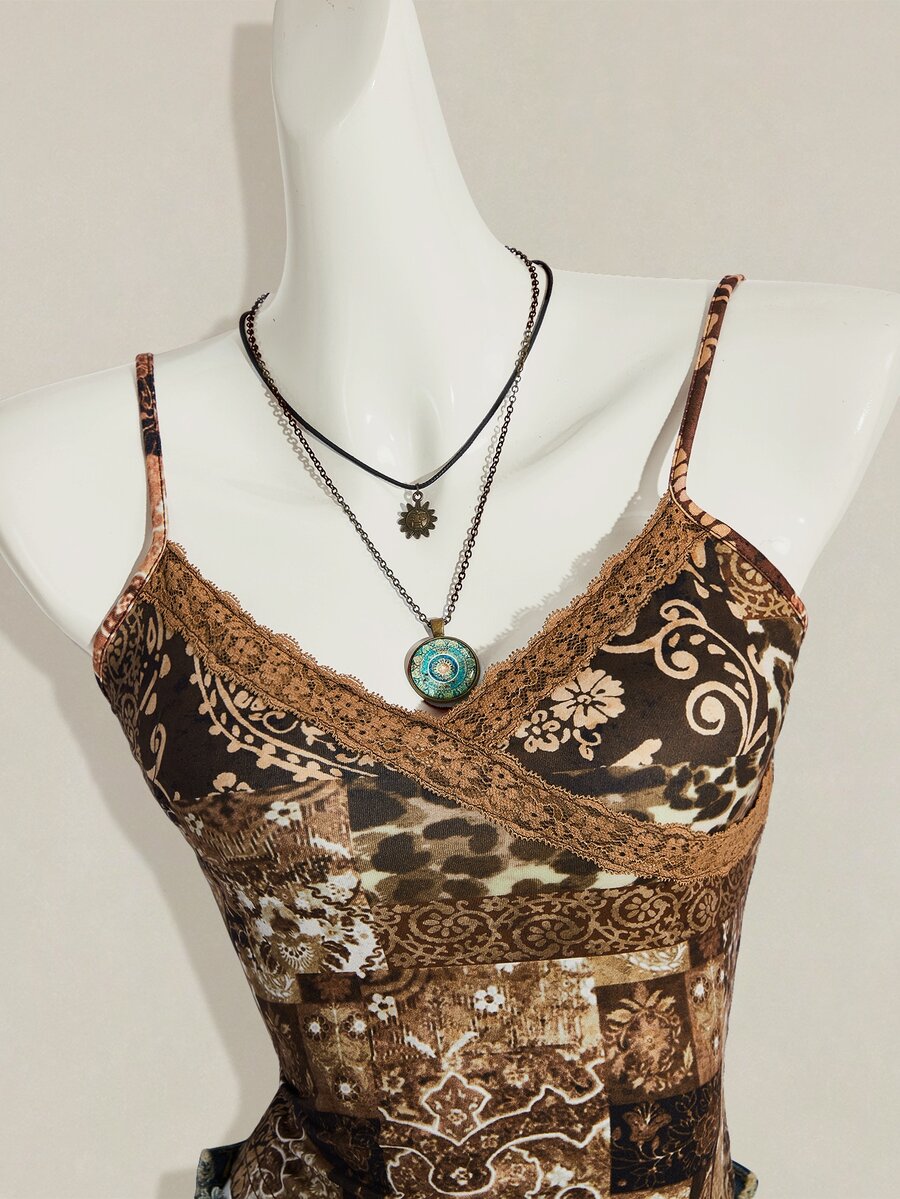 Women's blue fitted camisole top with contrast lace patchwork print, backless asymmetrical hem, and spaghetti straps.