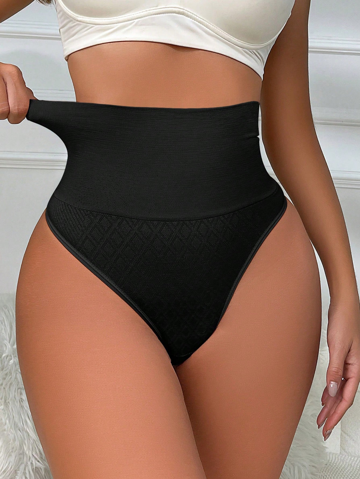 Black high waisted seamless shapewear thong for women featuring super high waist design and stretchy breathable fabric.