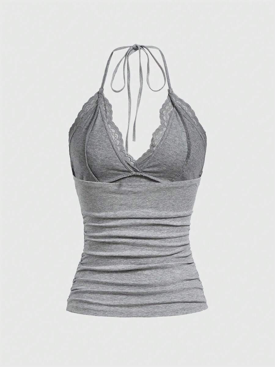 A women's black backless halter top featuring contrast lace trim, ruched front detail, and slim fit soft knitted fabric.