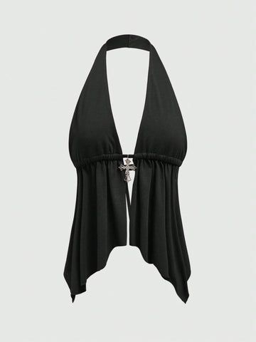 A women wearing a black halter crop top with a shiny rhinestone cross pendant, neck strap, backless cut, and asymmetrical ring detail.