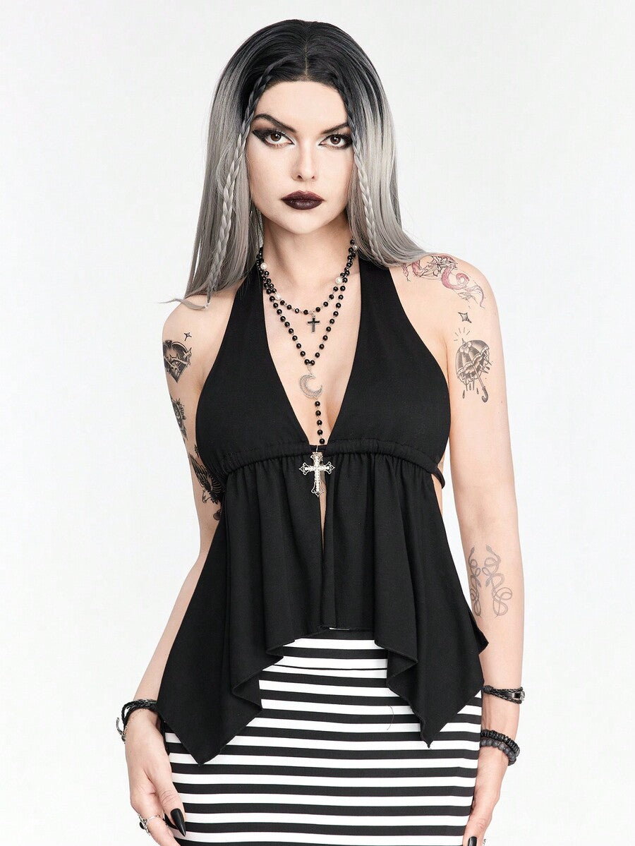 A women wearing a black halter crop top with a shiny rhinestone cross pendant, neck strap, backless cut, and asymmetrical ring detail.