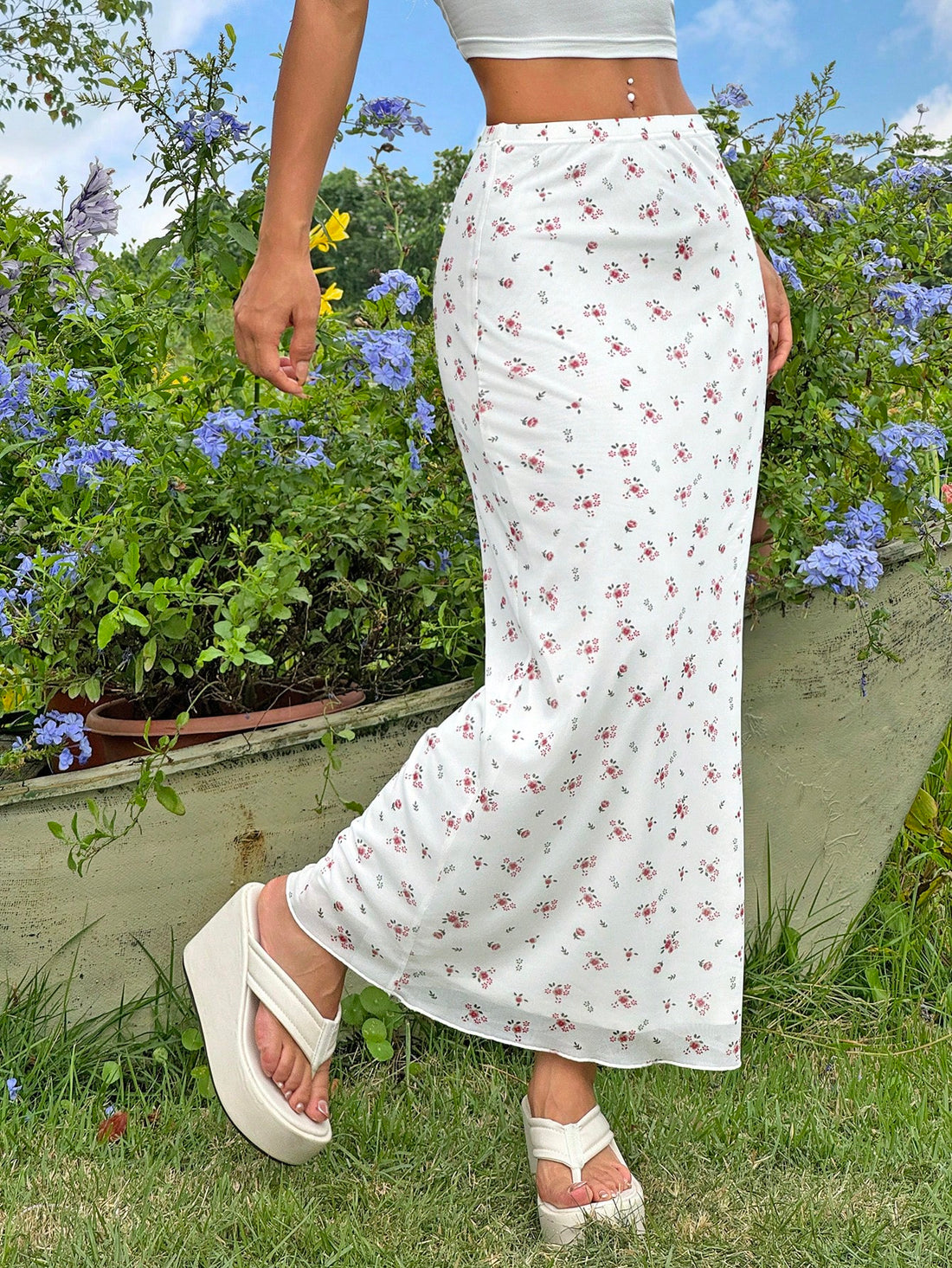 White ditsy floral pattern bodycon midi skirt with split thigh detail and boho mermaid silhouette on a model.