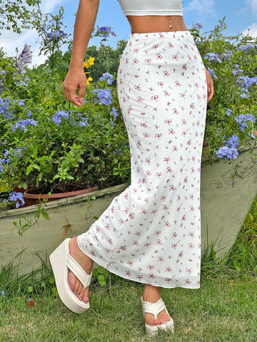 White ditsy floral pattern bodycon midi skirt with split thigh detail and boho mermaid silhouette on a model.