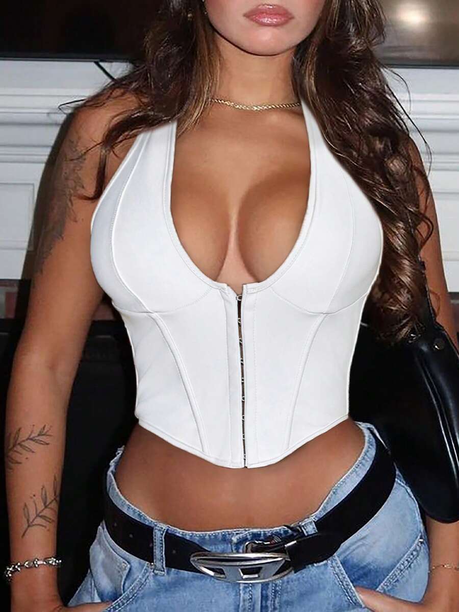 White Y2K PU leather camisole crop top featuring front grommet eyelet lace-up detailing, V-neckline, and backless silhouette on a model.