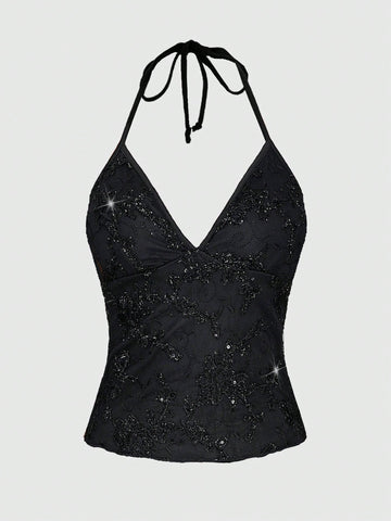 Women's black mesh sequin halter top featuring a backless design, knot details, and lace fabric.