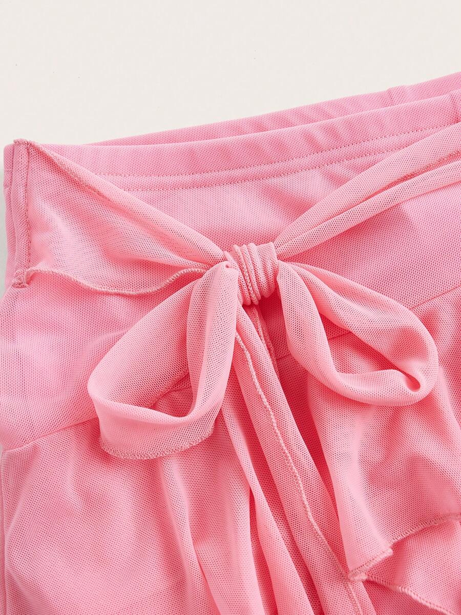White tiered ruffle trim mini skirt for women with low waist, knot detail, mesh fabric, and casual Y2K boho design.