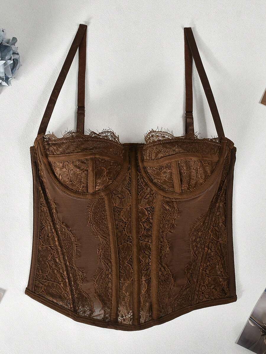 Black lace bustier corset top for women with asymmetrical contrast lace, lace-up detail, sleeveless crop cut, and light support.