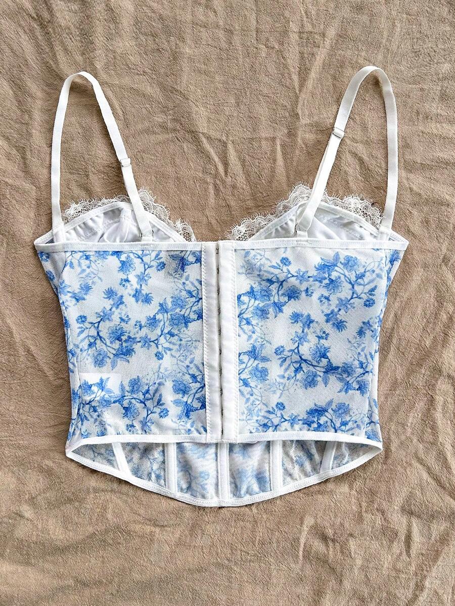 Women's lace bustier camisole top with spaghetti straps, contrast lace, lace-up detail, and an asymmetrical hem in a slim fit design.