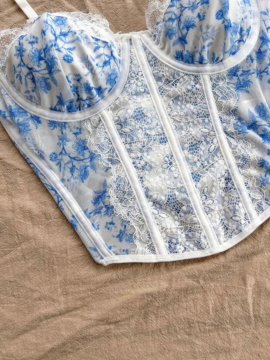 Women's lace bustier camisole top with spaghetti straps, contrast lace, lace-up detail, and an asymmetrical hem in a slim fit design.