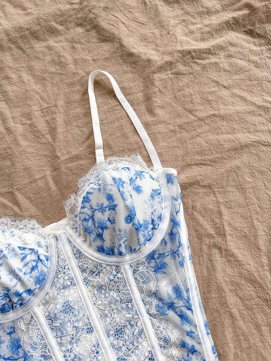 Women's lace bustier camisole top with spaghetti straps, contrast lace, lace-up detail, and an asymmetrical hem in a slim fit design.