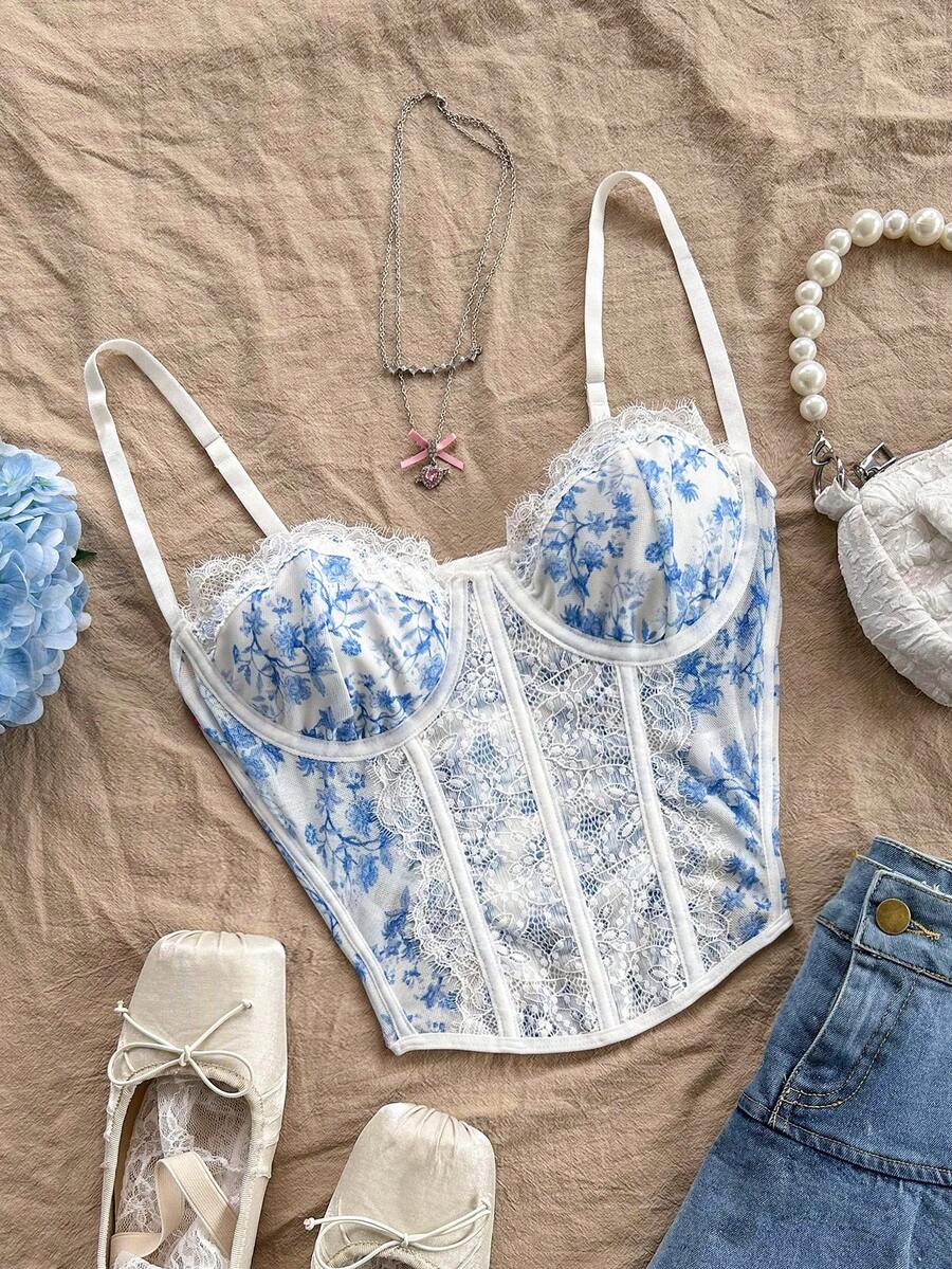 Women's lace bustier camisole top with spaghetti straps, contrast lace, lace-up detail, and an asymmetrical hem in a slim fit design.