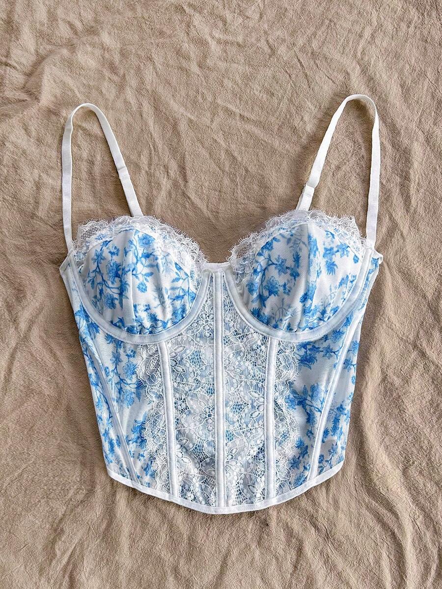 Women's lace bustier camisole top with spaghetti straps, contrast lace, lace-up detail, and an asymmetrical hem in a slim fit design.
