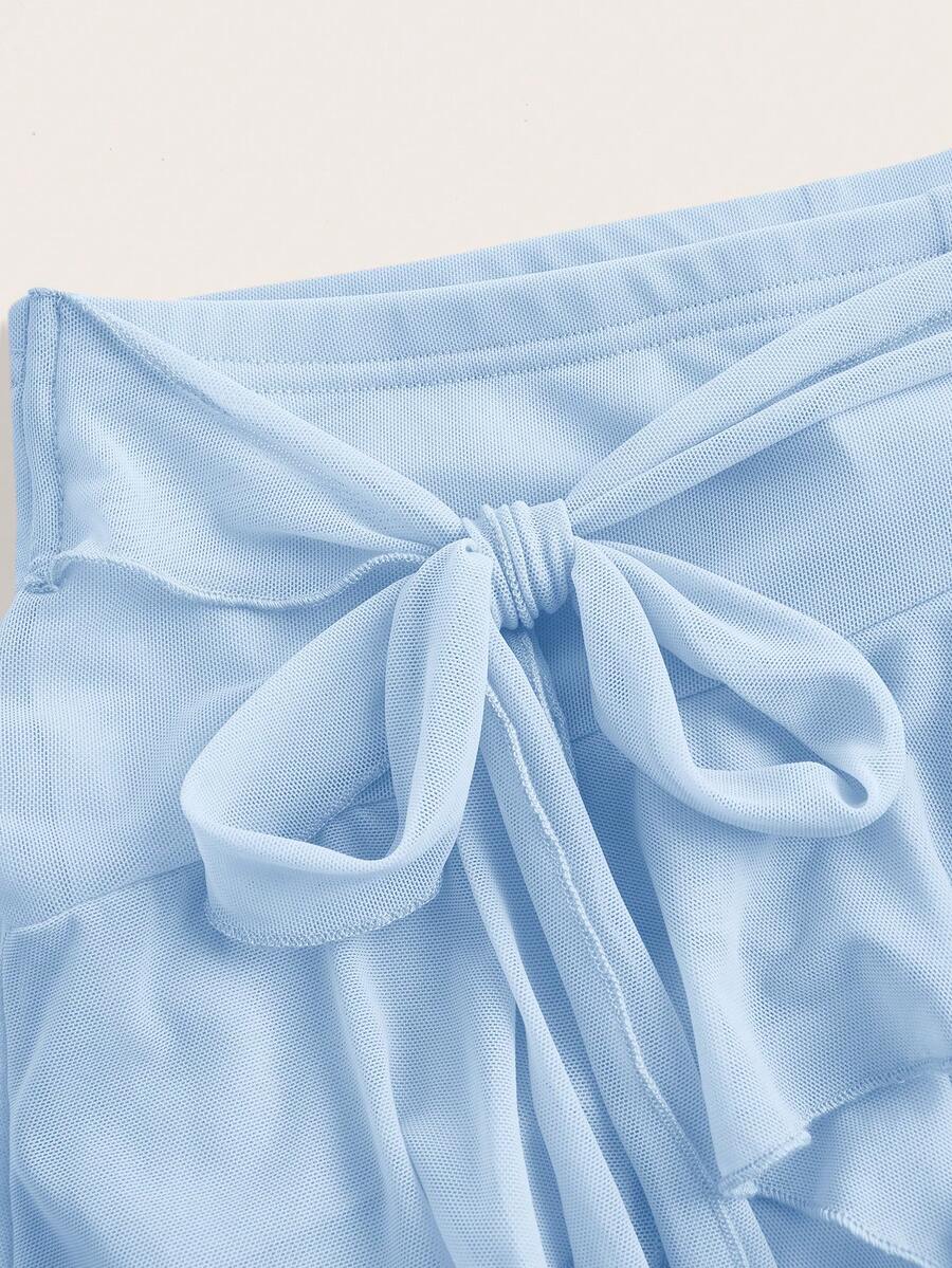 White tiered ruffle trim mini skirt for women with low waist, knot detail, mesh fabric, and casual Y2K boho design.