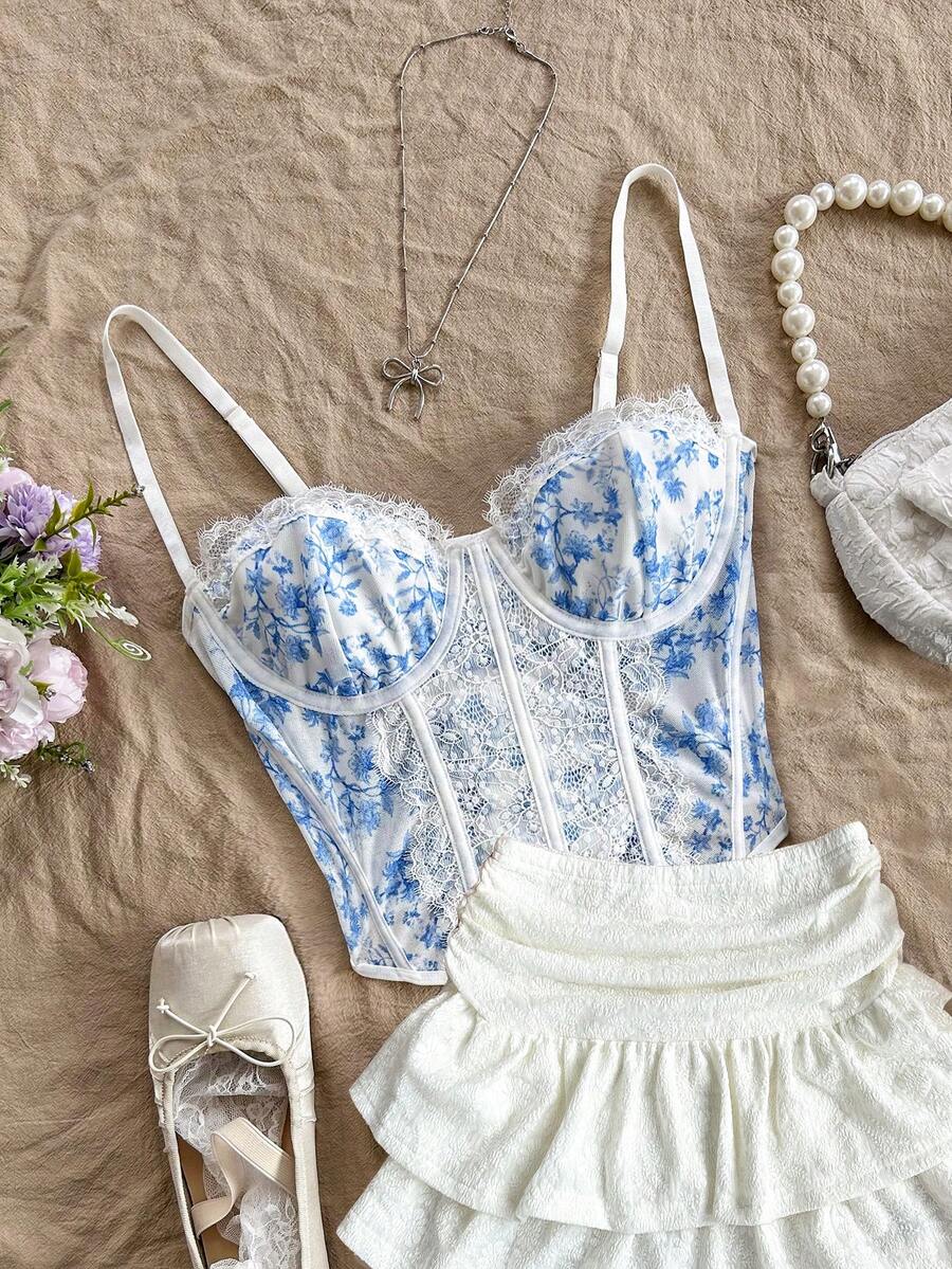 Women's lace bustier camisole top with spaghetti straps, contrast lace, lace-up detail, and an asymmetrical hem in a slim fit design.