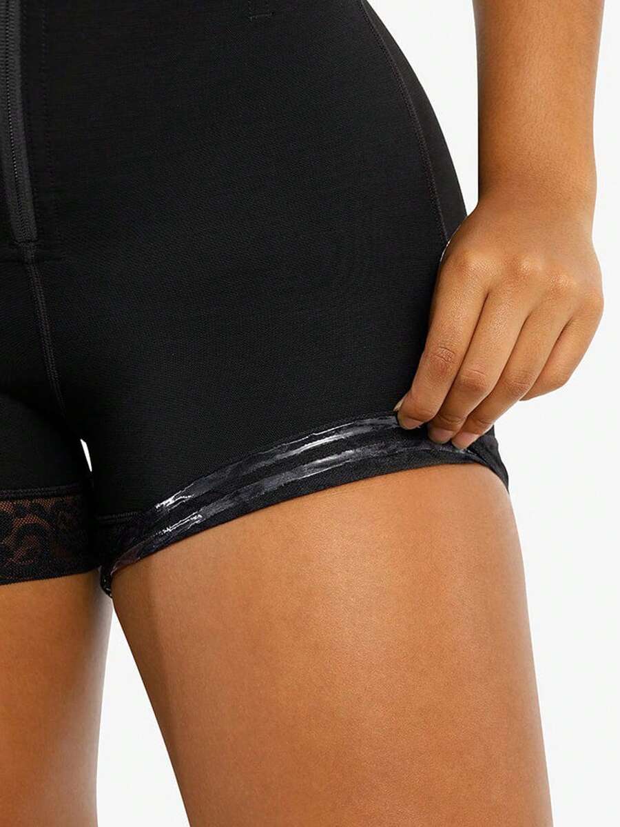 Black high waist butt lifting shapewear shorts made from mesh fabric with contrast lace trim and a front zipper for tummy and thigh shaping.
