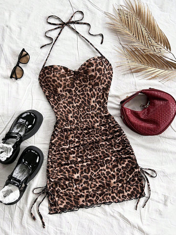 Multicolor leopard print sleeveless halter mini dress for women featuring a backless design, ruched drawstring hem, and slim fit.
