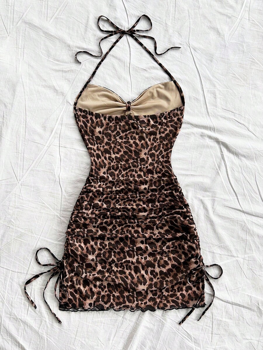 Multicolor leopard print sleeveless halter mini dress for women featuring a backless design, ruched drawstring hem, and slim fit.