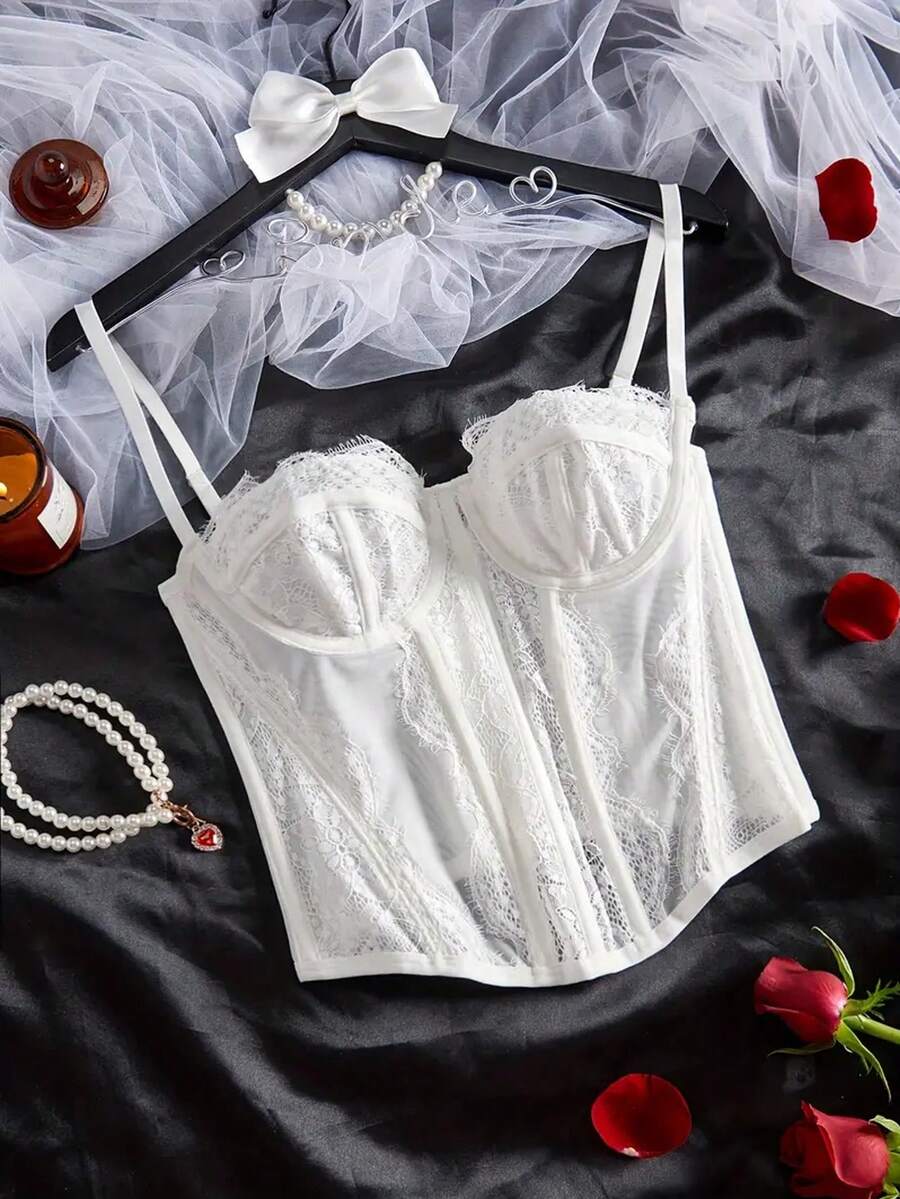 Black lace bustier corset top for women with asymmetrical contrast lace, lace-up detail, sleeveless crop cut, and light support.