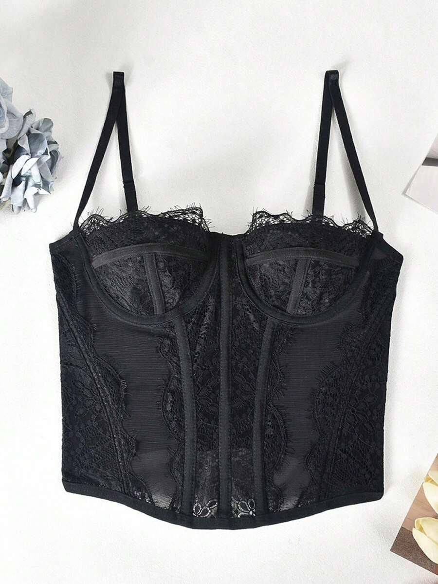 Black lace bustier corset top for women with asymmetrical contrast lace, lace-up detail, sleeveless crop cut, and light support.