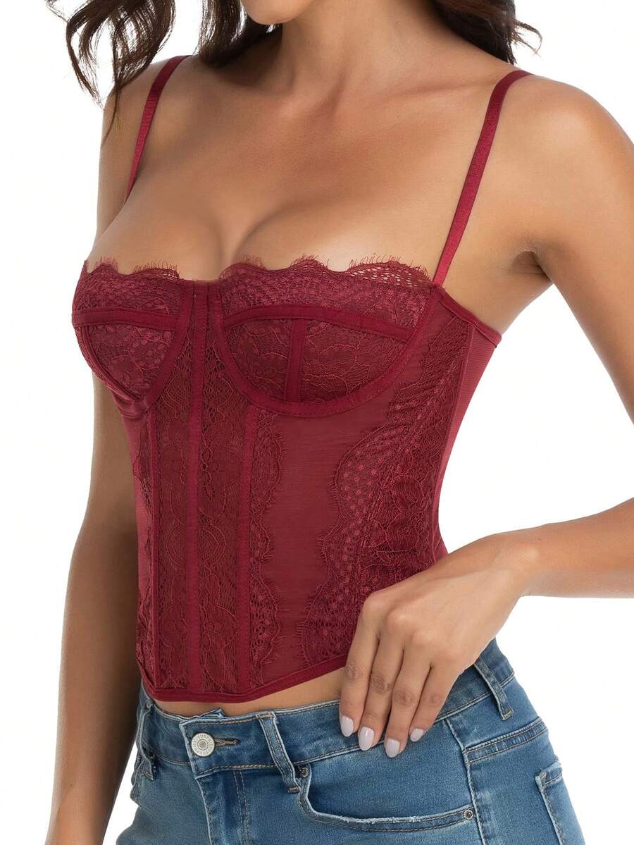 Black lace bustier corset top for women with asymmetrical contrast lace, lace-up detail, sleeveless crop cut, and light support.