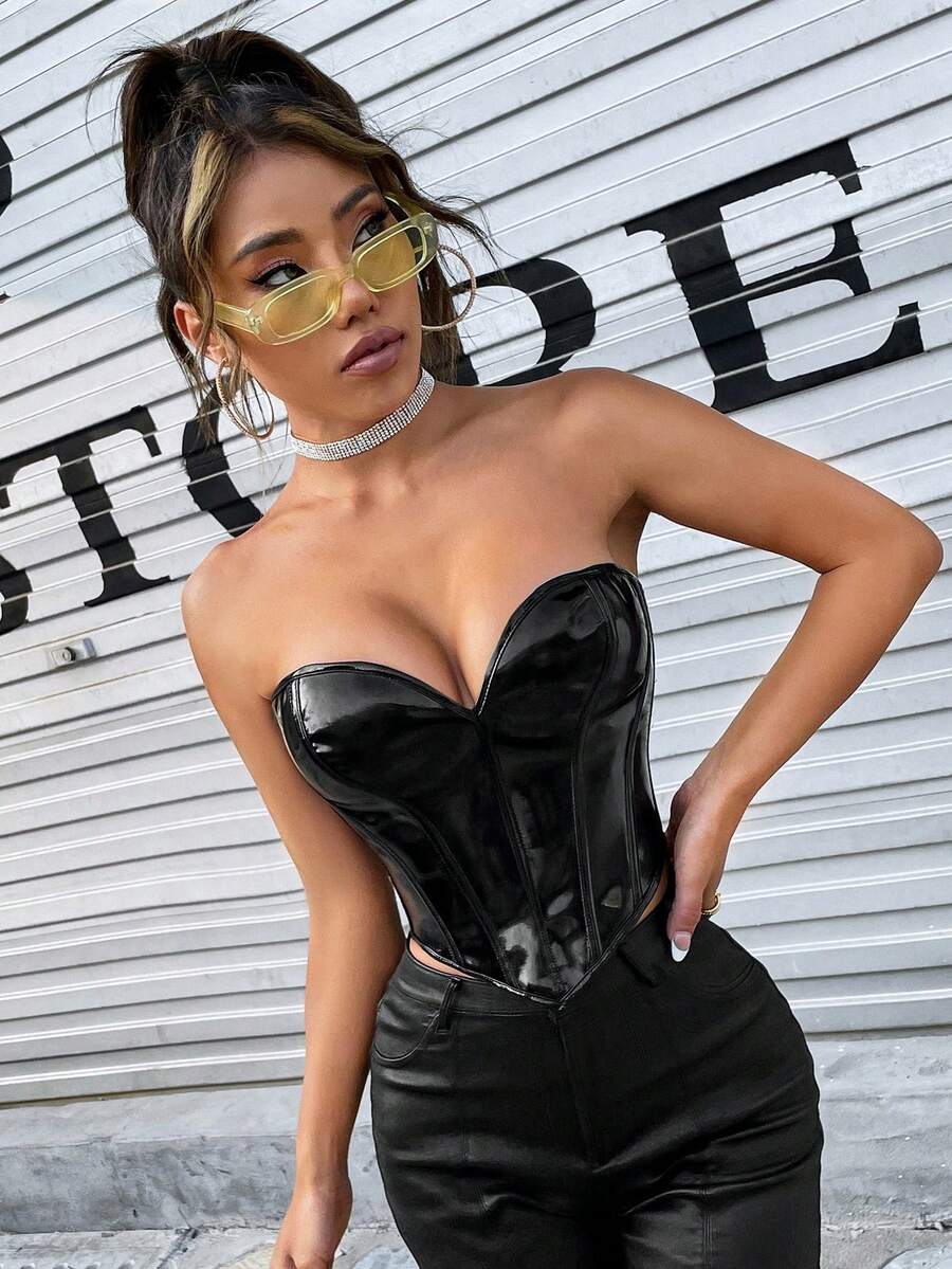 Black PU leather lace-up bustier crop top for women by Apperloth featuring a strapless asymmetrical hem with grommet eyelets.