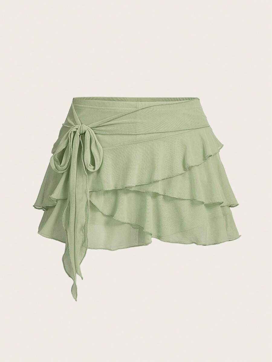 White tiered ruffle trim mini skirt for women with low waist, knot detail, mesh fabric, and casual Y2K boho design.