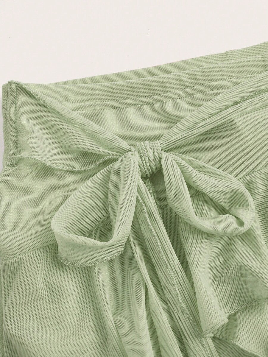 White tiered ruffle trim mini skirt for women with low waist, knot detail, mesh fabric, and casual Y2K boho design.