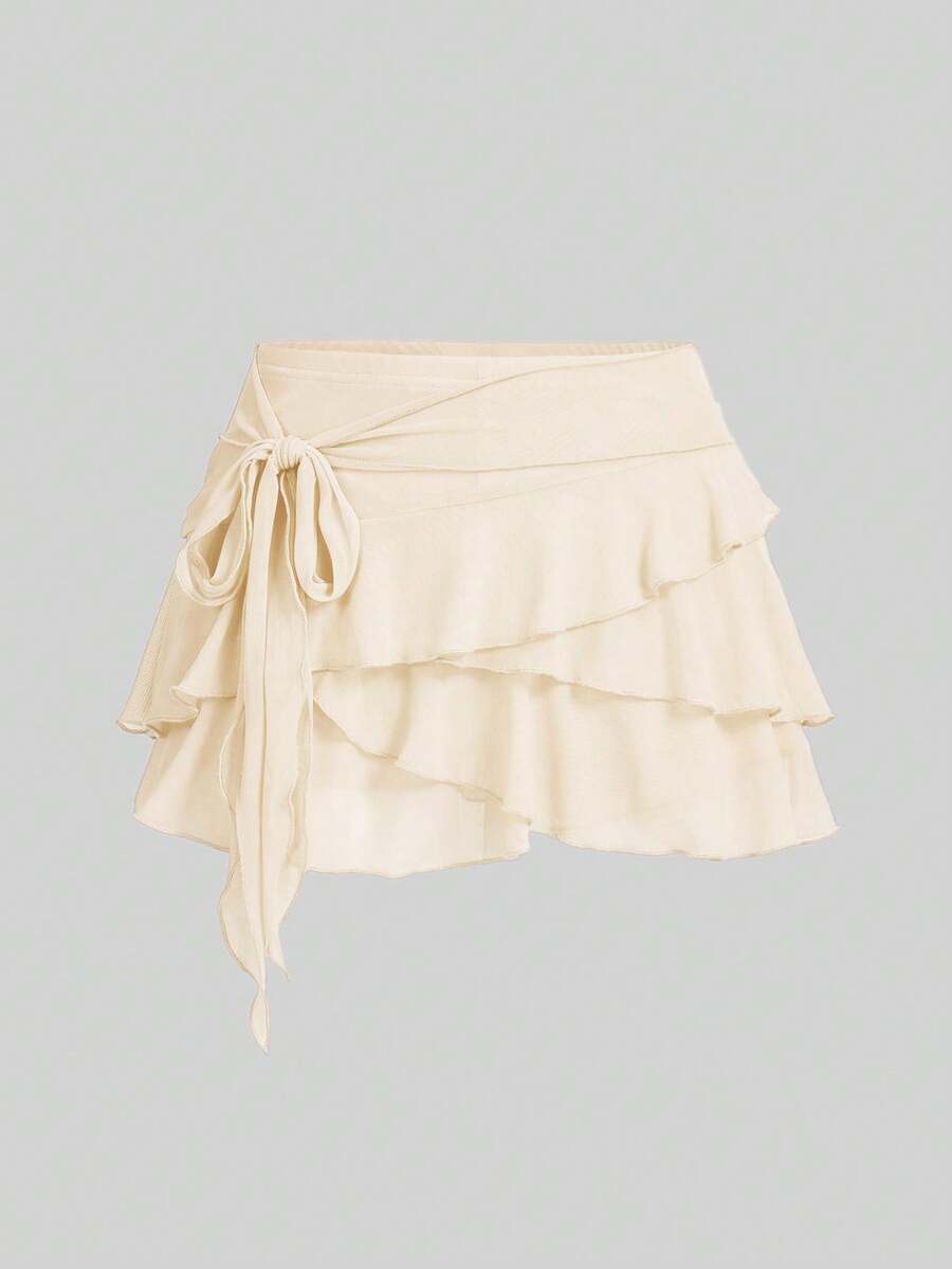 White tiered ruffle trim mini skirt for women with low waist, knot detail, mesh fabric, and casual Y2K boho design.