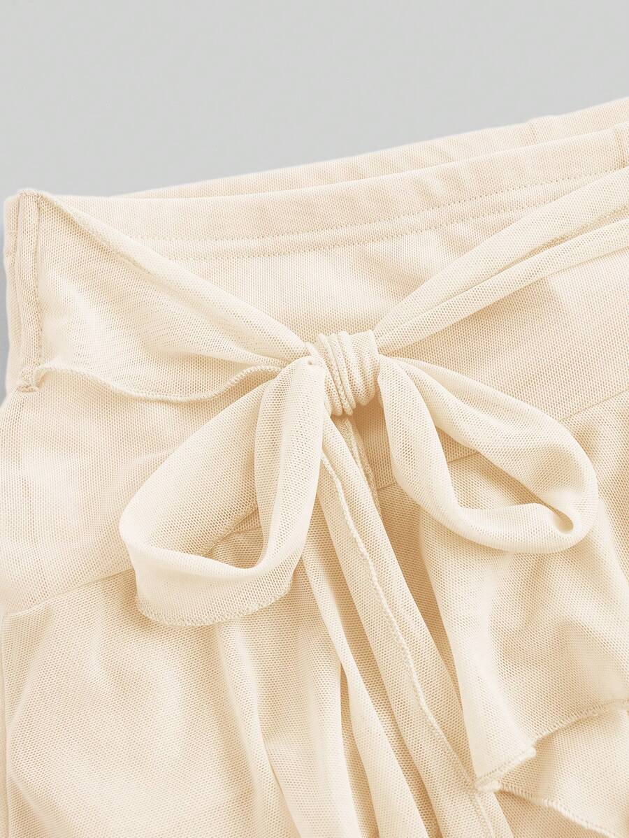White tiered ruffle trim mini skirt for women with low waist, knot detail, mesh fabric, and casual Y2K boho design.