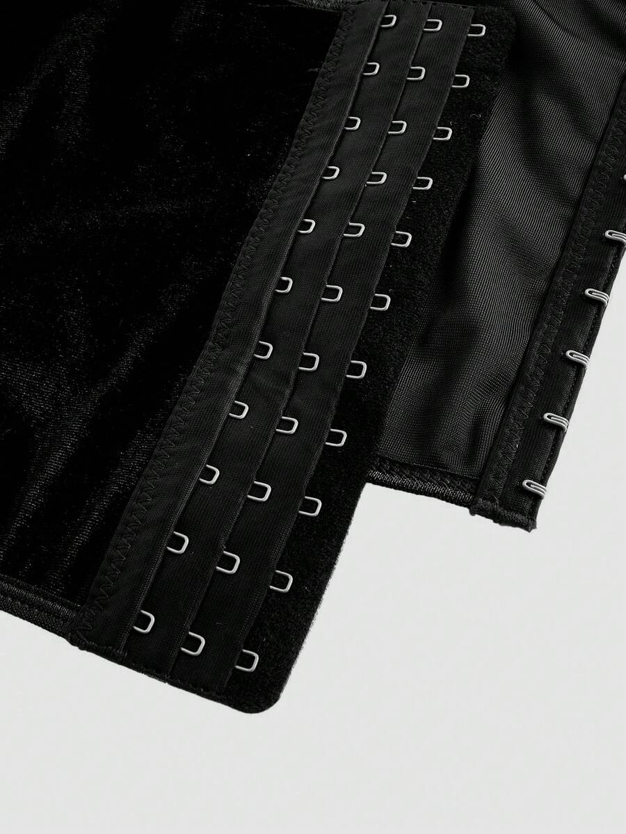 A women's black velvet crop camisole top featuring criss-cross shoulder straps, asymmetrical cut-out details, and a sleeveless vest neckline.