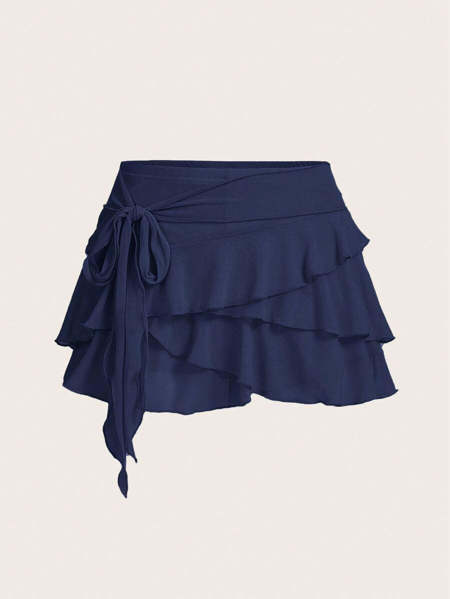White tiered ruffle trim mini skirt for women with low waist, knot detail, mesh fabric, and casual Y2K boho design.
