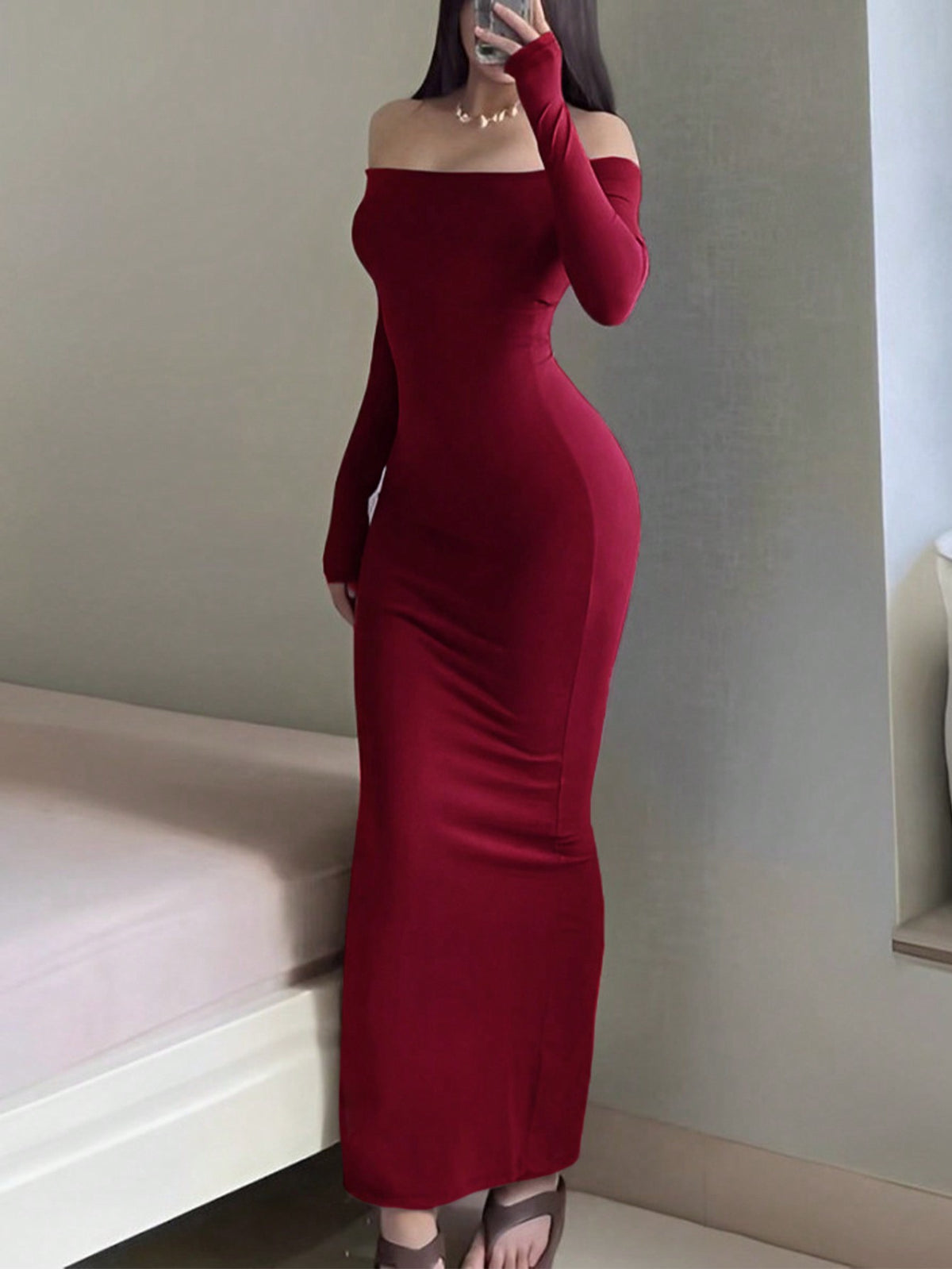 Woman wearing an elegant off-the-shoulder bodycon long dress with backless design and pencil silhouette in high-stretch knitted fabric.