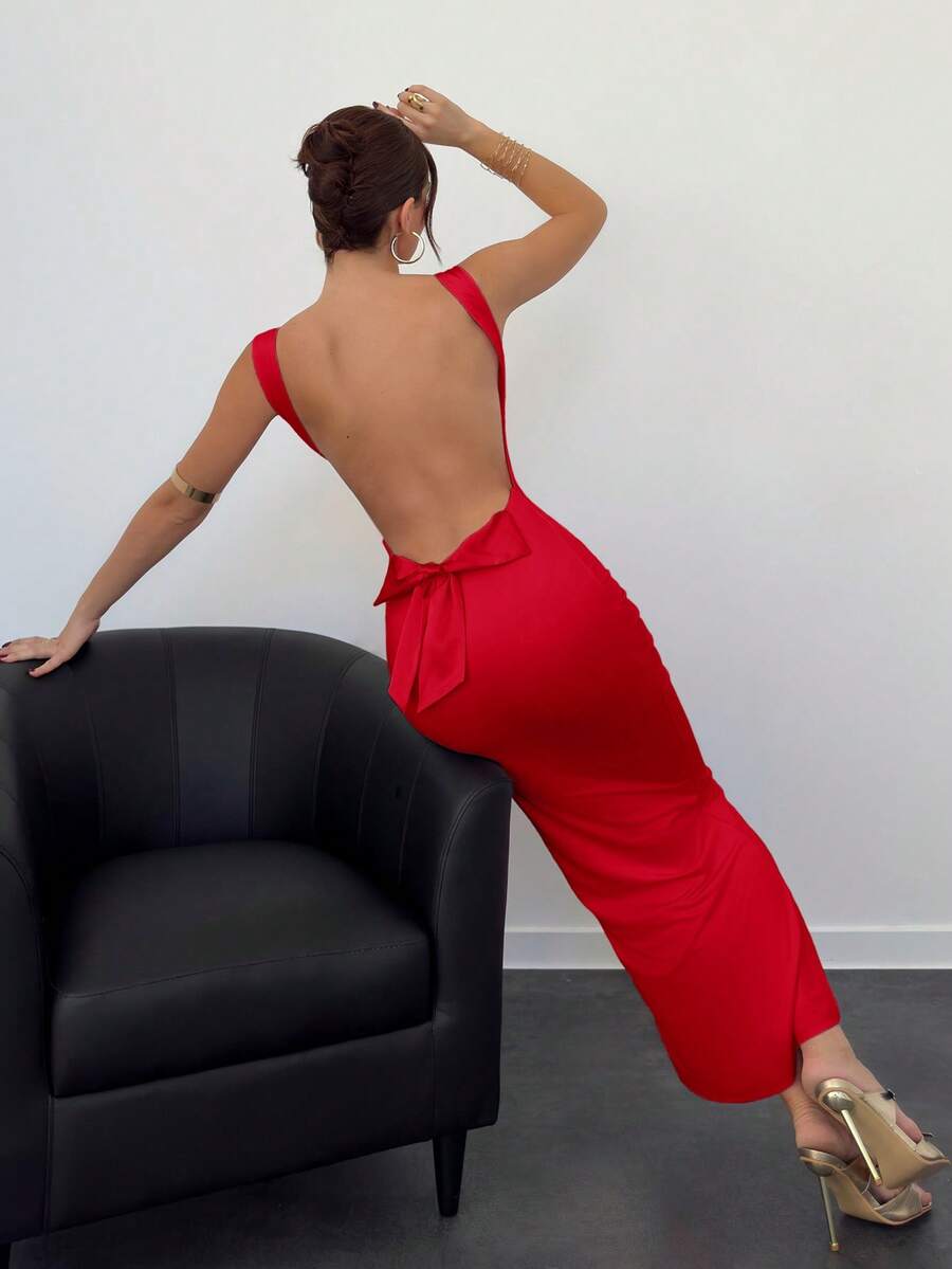 Beige sleeveless backless cami maxi dress for women featuring bow decor, split hem, and slim fit knitted fabric.