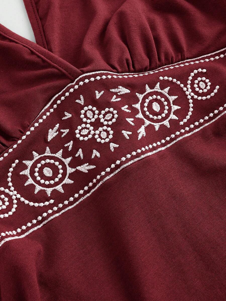 Women's sun totem embroidered sleeveless layered mini dress featuring a halter neck, backless tie back design, and slim fit high-waist A-line silhouette.