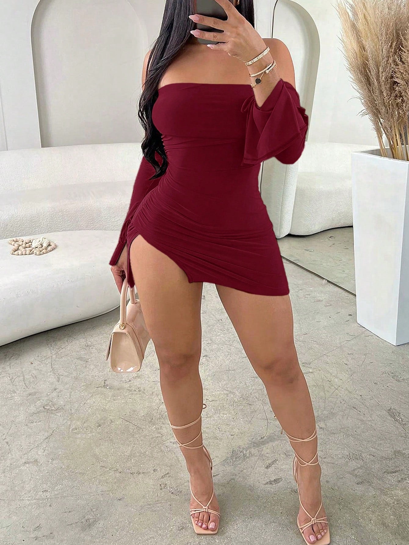 White off-the-shoulder sleeveless bodycon mini dress featuring ruched details, backless design, and asymmetrical high-split hem.