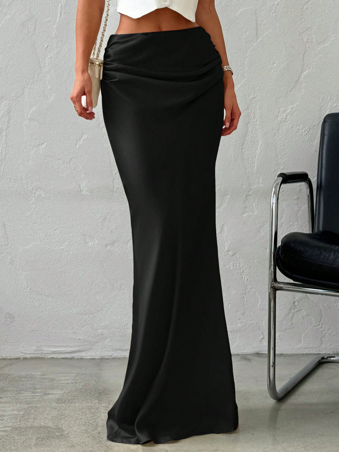Women's black solid satin maxi skirt featuring an asymmetrical ruched design, ultra low waist, straight fit, and zipper closure.
