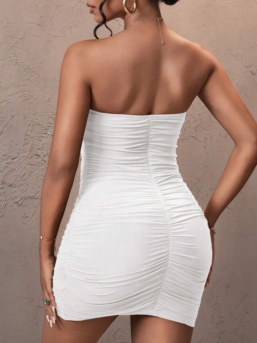 Woman wearing a solid black strapless ruched bodycon mini dress featuring a backless slim fit design in high-stretch mesh fabric.