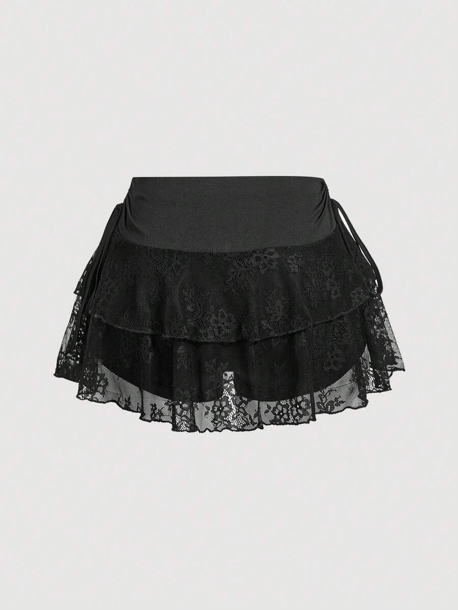 A woman wearing a black lace tiered ruffle mini skirt skort featuring a mid-waist design and layered hemline.