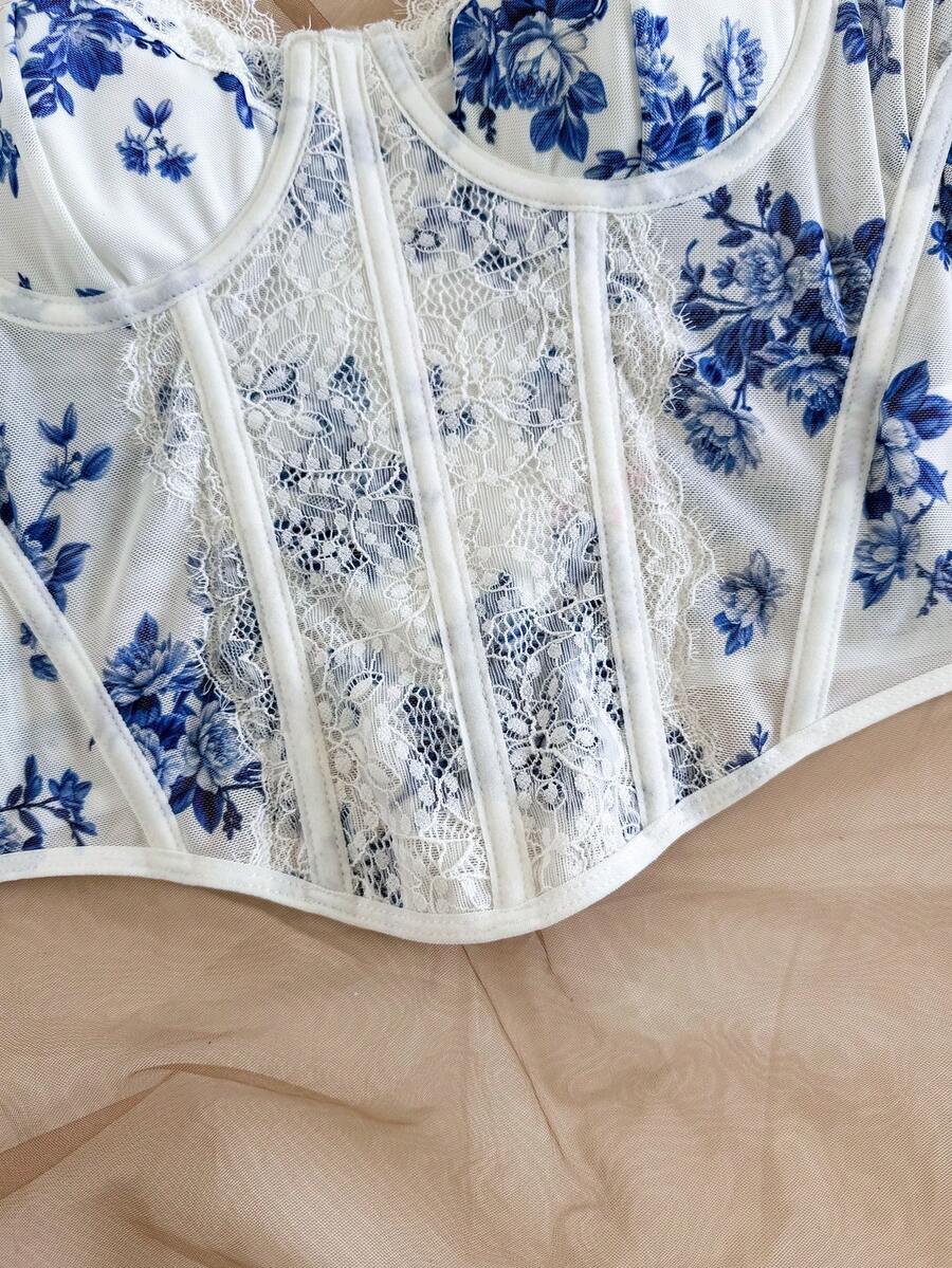 Women's lace bustier camisole top with spaghetti straps, contrast lace, lace-up detail, and an asymmetrical hem in a slim fit design.