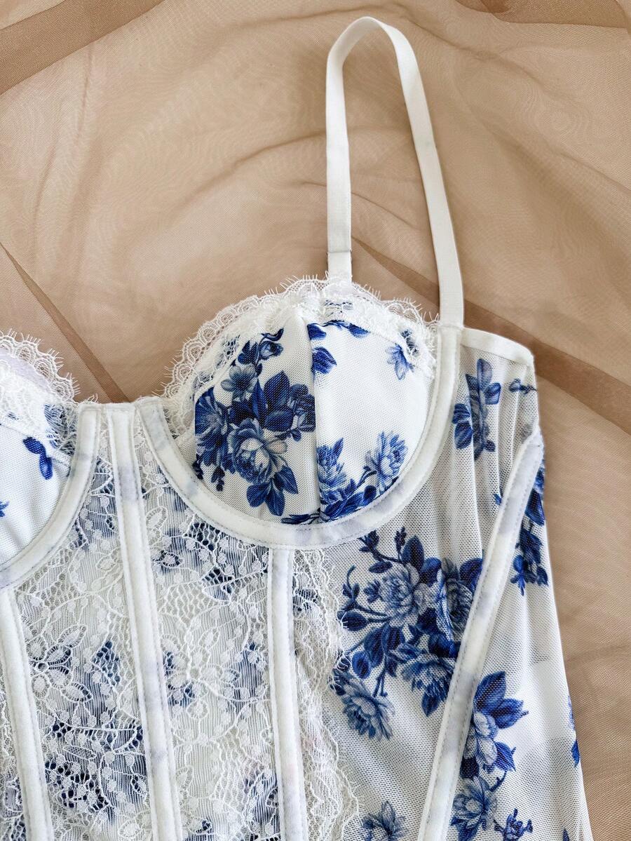 Women's lace bustier camisole top with spaghetti straps, contrast lace, lace-up detail, and an asymmetrical hem in a slim fit design.