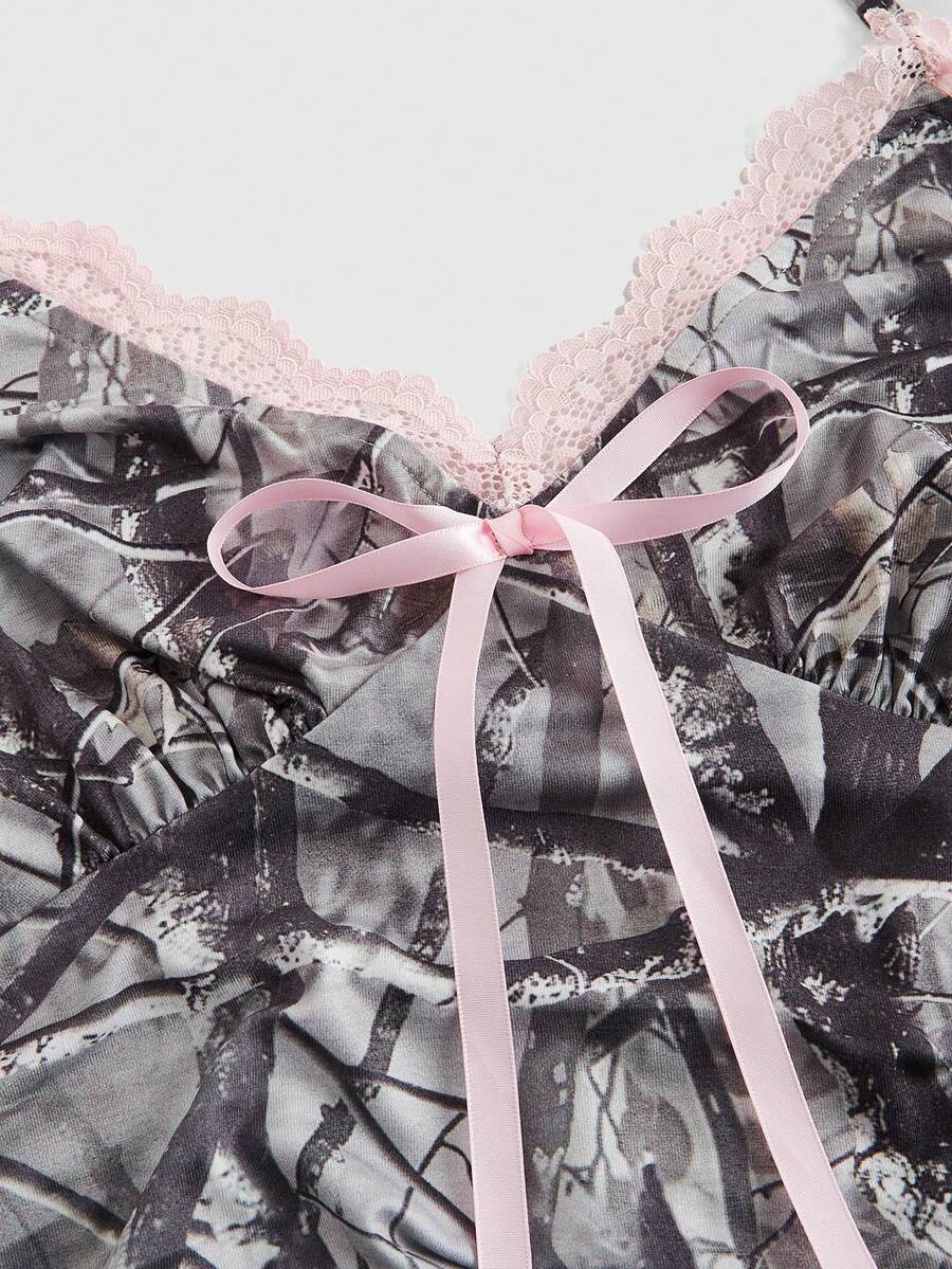 Women's slim fit camo crop tank top styled with contrast lace trim, front bow accent, and matching arm sleeves.