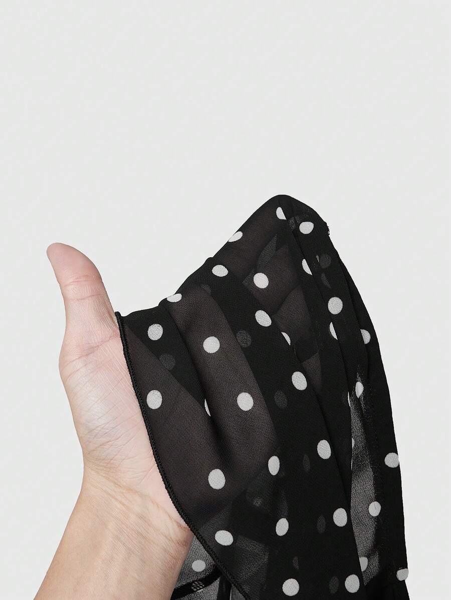 Black halter crop top featuring an asymmetrical ruffle hem and backless design for women.