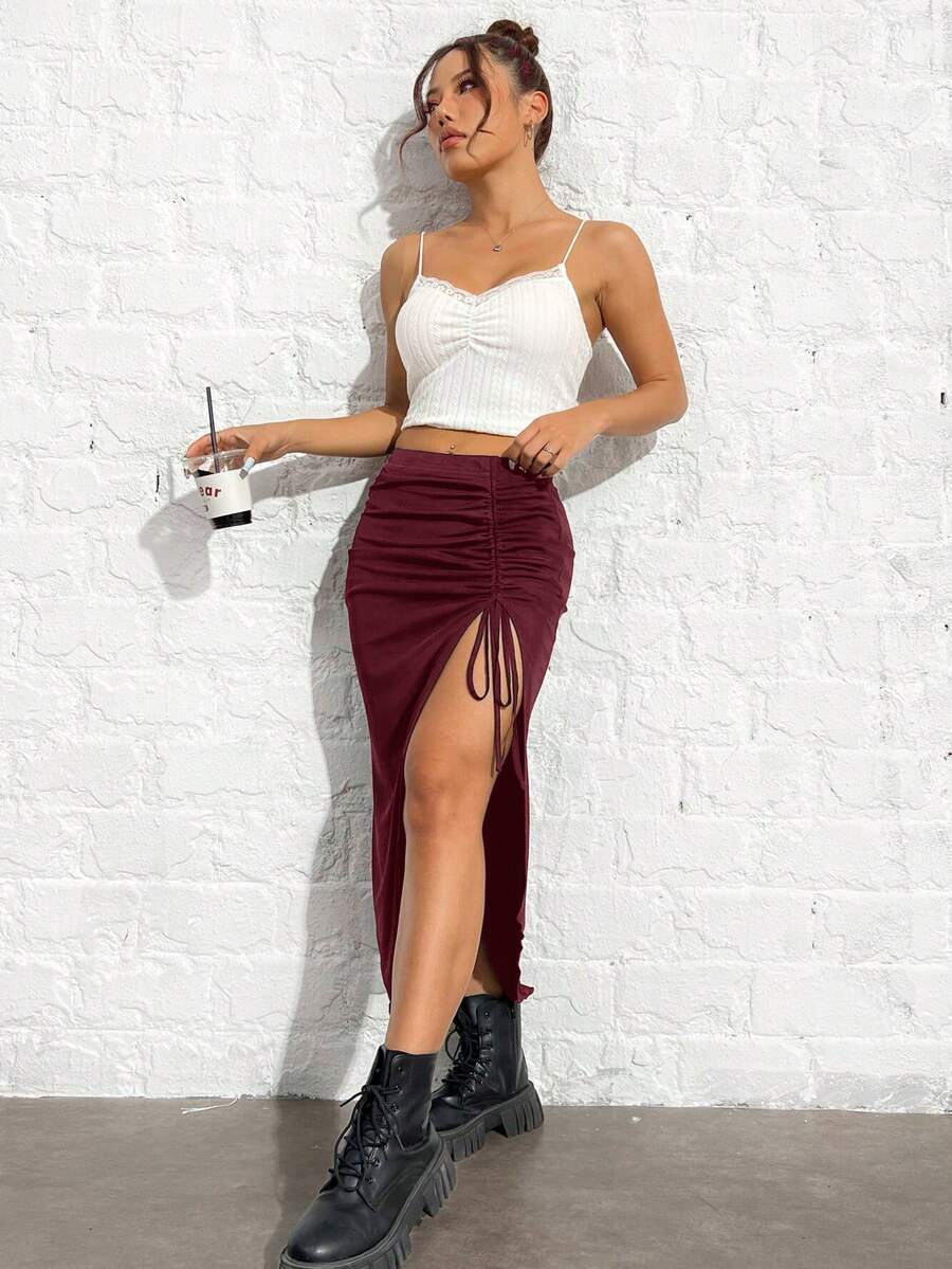 Women's black high-waisted bodycon long skirt featuring a drawstring split thigh detail and mesh fabric.
