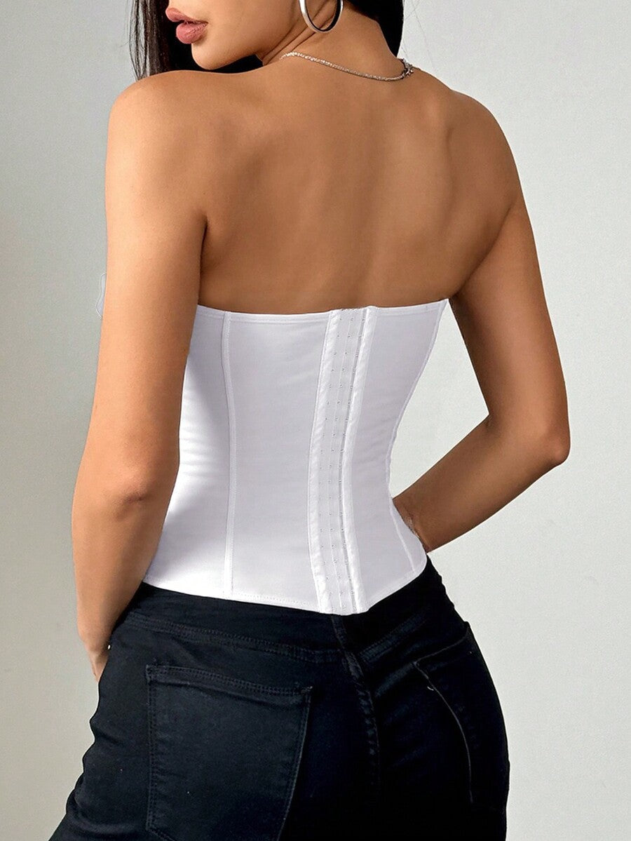 Women’s strapless corset crop top with padded cups, structured support, lace-up back, hook-and-eye closure, and an asymmetrical hem in white.