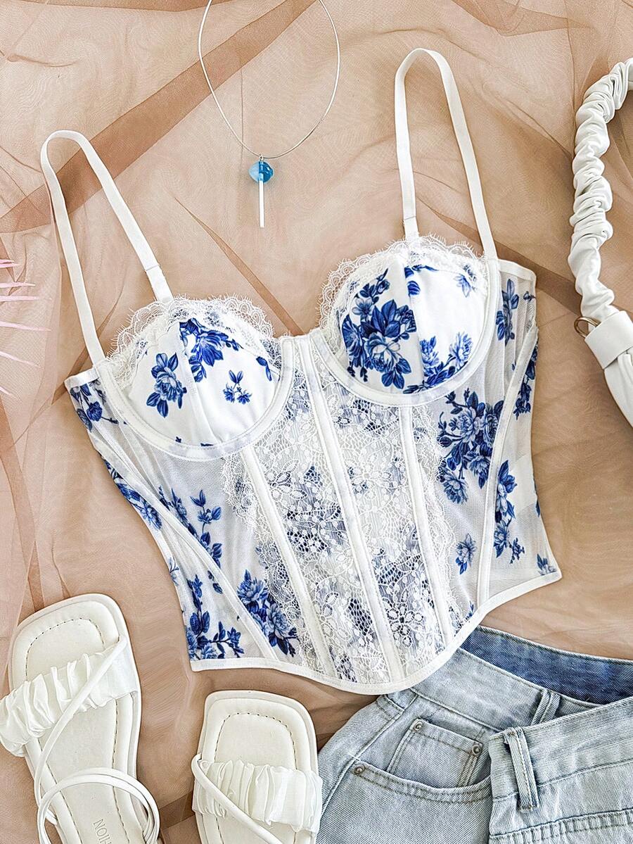 Women's lace bustier camisole top with spaghetti straps, contrast lace, lace-up detail, and an asymmetrical hem in a slim fit design.