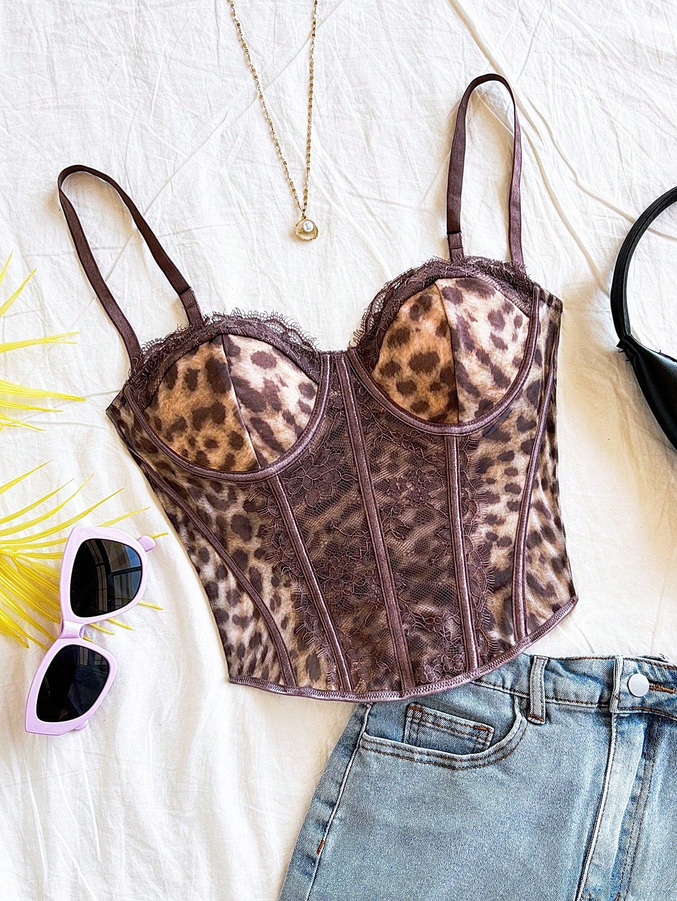 Women's lace bustier camisole top with spaghetti straps, contrast lace, lace-up detail, and an asymmetrical hem in a slim fit design.