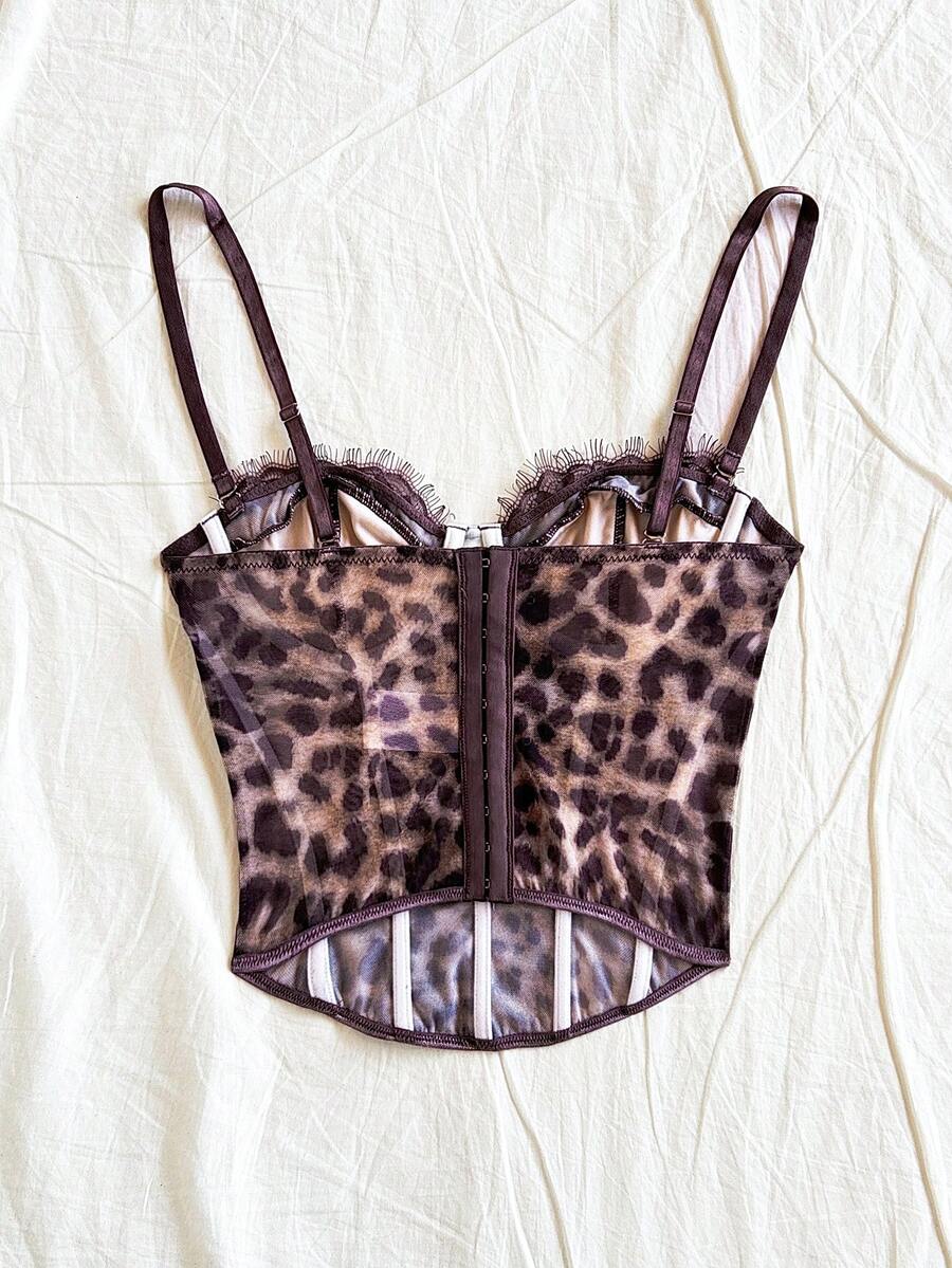 Women's lace bustier camisole top with spaghetti straps, contrast lace, lace-up detail, and an asymmetrical hem in a slim fit design.