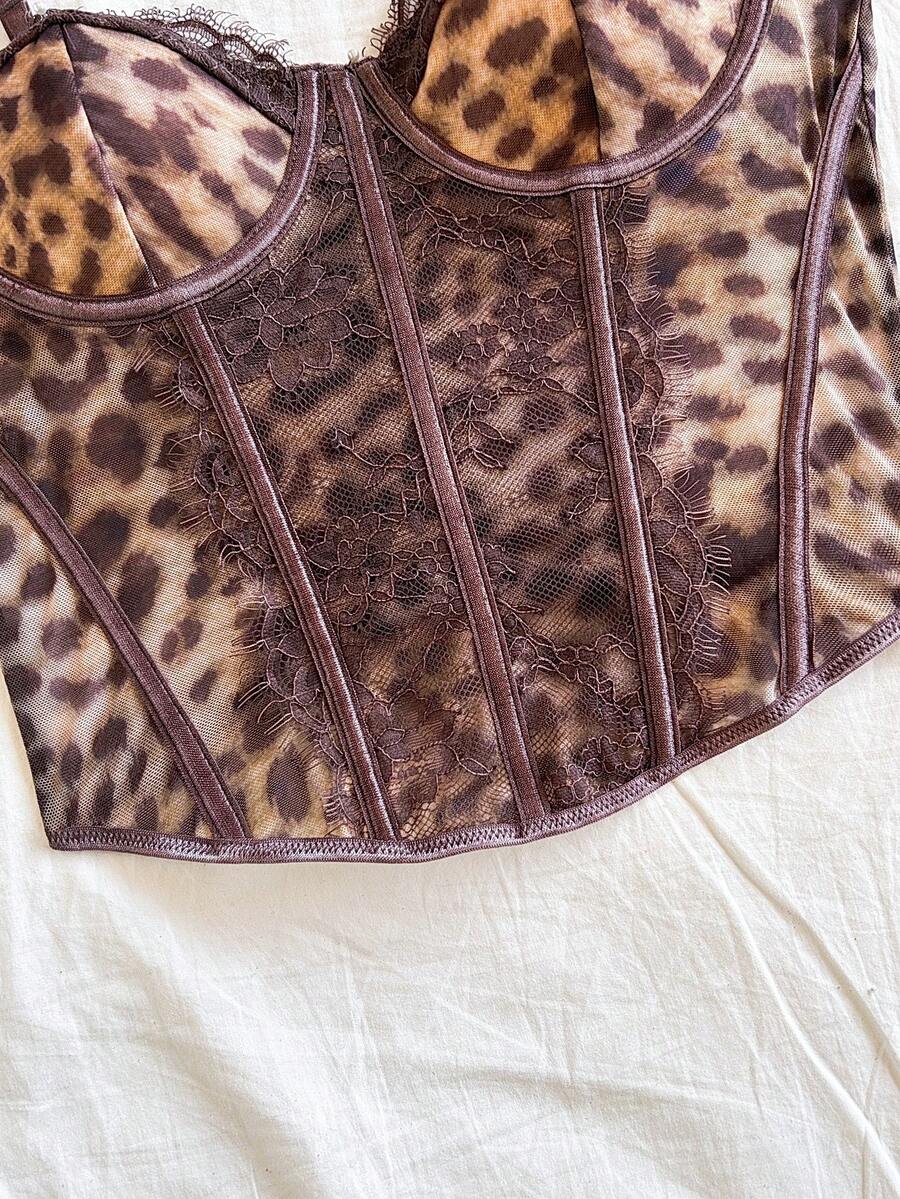 Women's lace bustier camisole top with spaghetti straps, contrast lace, lace-up detail, and an asymmetrical hem in a slim fit design.