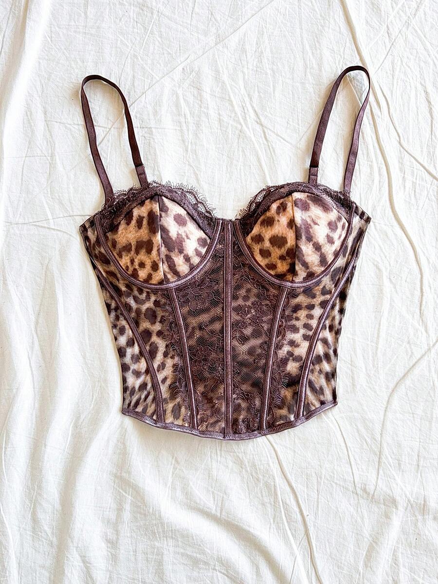 Women's lace bustier camisole top with spaghetti straps, contrast lace, lace-up detail, and an asymmetrical hem in a slim fit design.