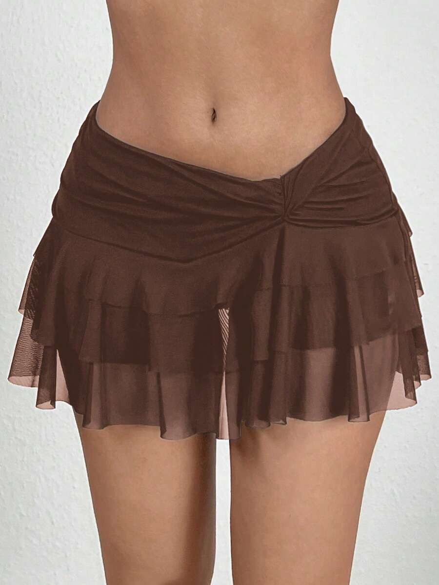 Black tiered ruffle mini cake skirt for women featuring a mid-waist pleated design and layered ruffle hem.